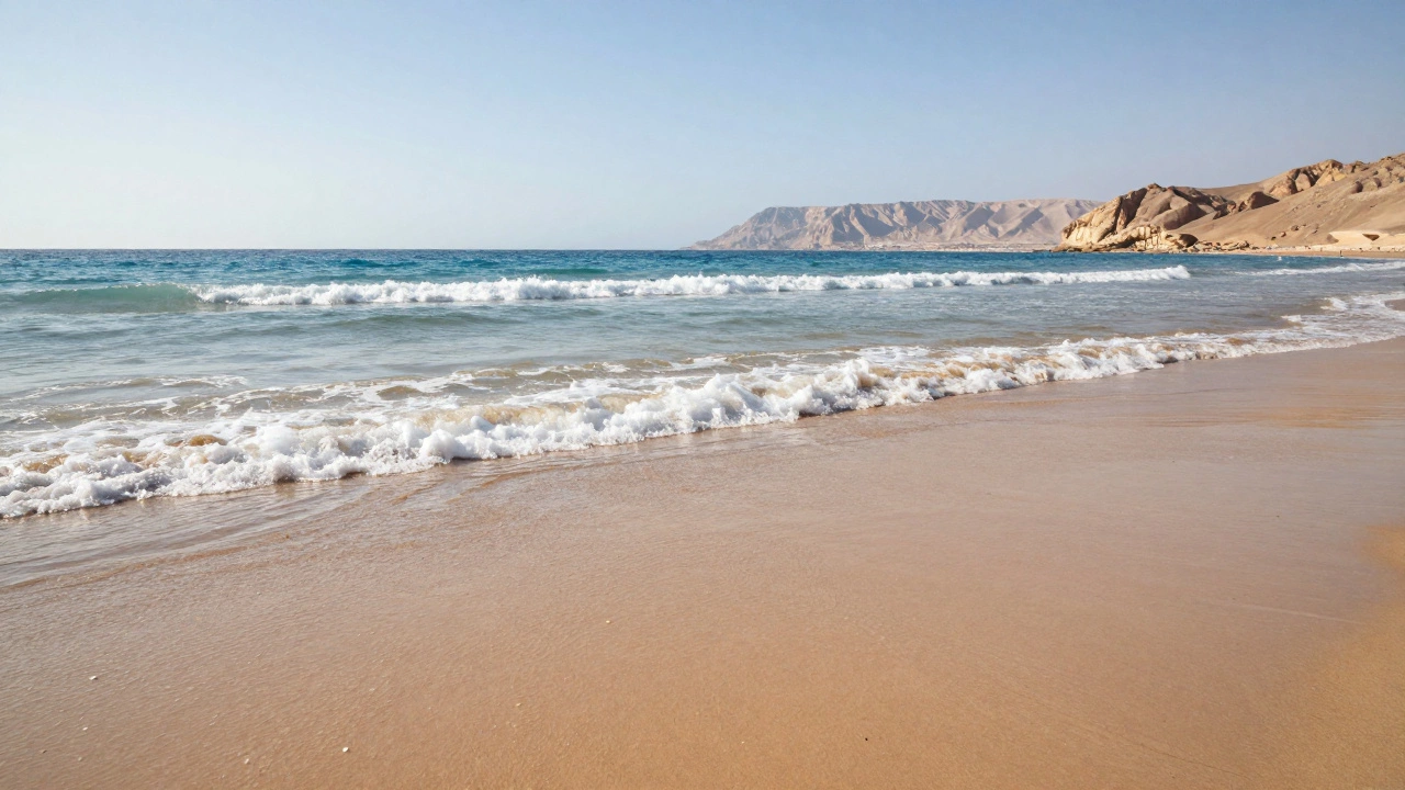 Пустой пляж Эйлата, Израиль, с морским аэрозолем, мерцающим в утреннем свете, без растительности и загрязнений.
